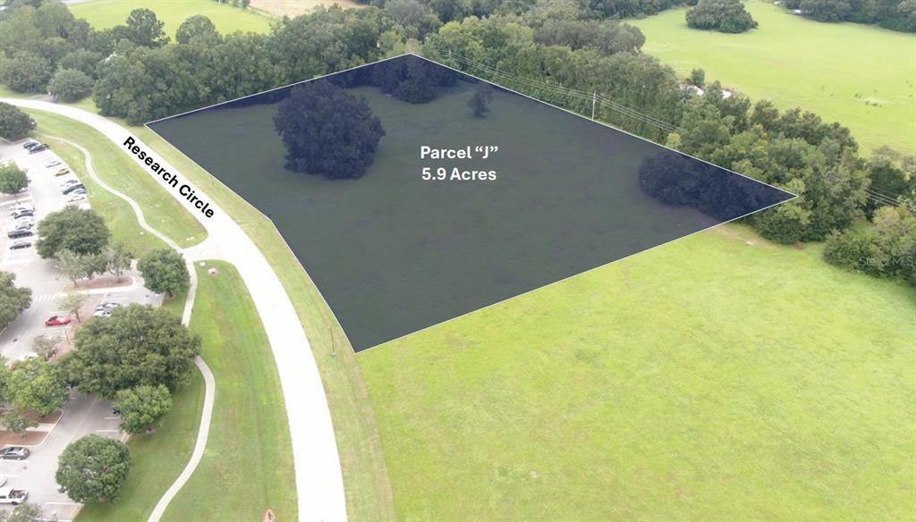 An aerial view shows a 5.9-acre parcel of land highlighted in black next to a road — RESEARCH CIRCLE, ALACHUA, FL