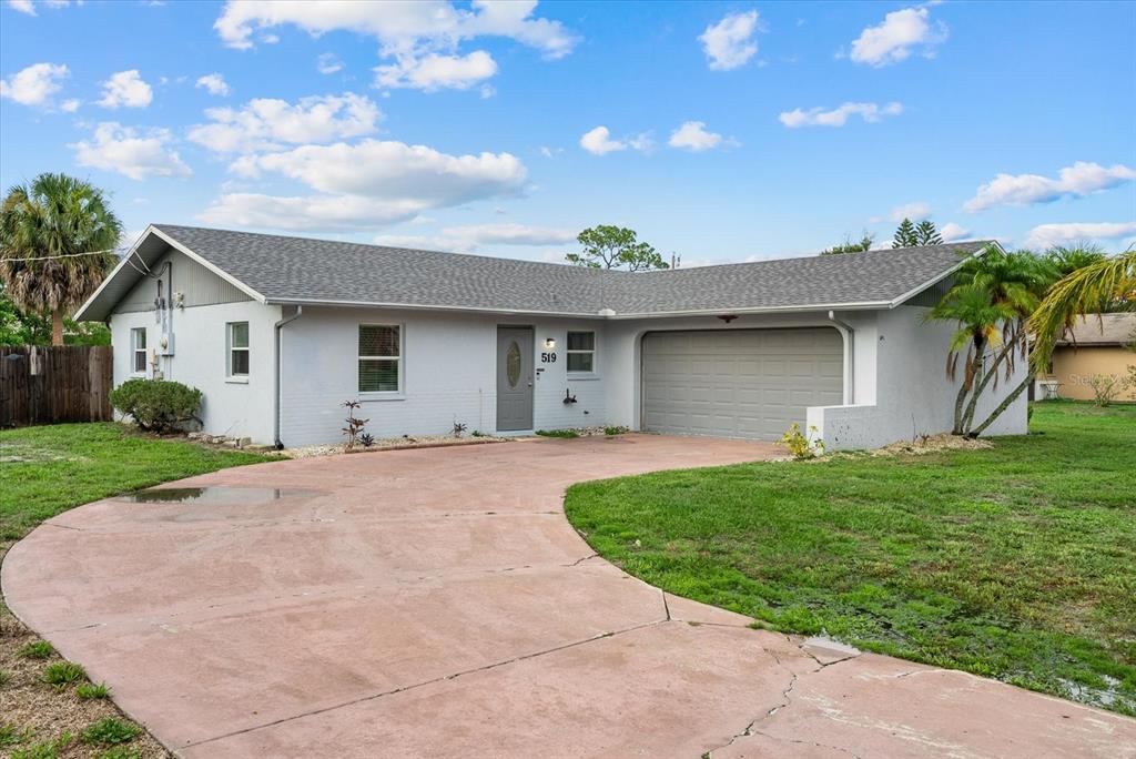A single-story house with a gray exterior, a two-car garage, and a curved concrete driveway — 519 64TH AVENUE DRIVE E, BRADENTON, FL