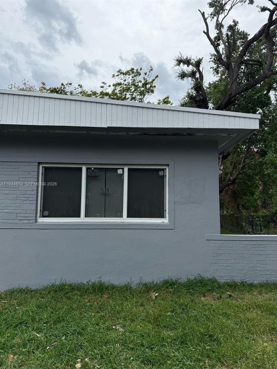 A gray exterior wall features a horizontal window with white trim and a textured section — 170 NE 68th Ter, Miami FL 33138, MIAMI, FL