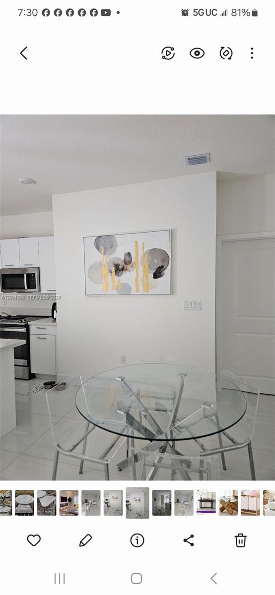 A dining area features a glass-topped table, clear chairs, and abstract wall art — 8167 NW 41st St # 109, Doral FL 33166, DORAL, FL