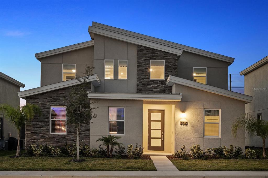 A two-story modern house features a stone facade, a shed roof, and a front entrance — 9012 SOMMERSET HILLS DRIVE, DAVENPORT, FL