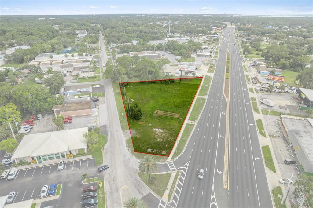 An aerial view shows a vacant, triangular-shaped lot situated between a highway and a side road — 00 US HWY 19, PORT RICHEY, FL