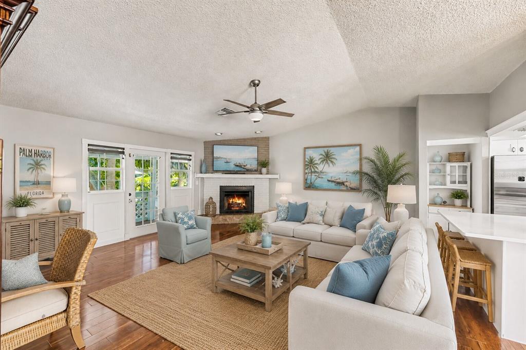 A two-story house exterior features a ground-level patio, a second-story balcony, and a grassy yard — 4941 CARDINAL TRAIL, PALM HARBOR, FL