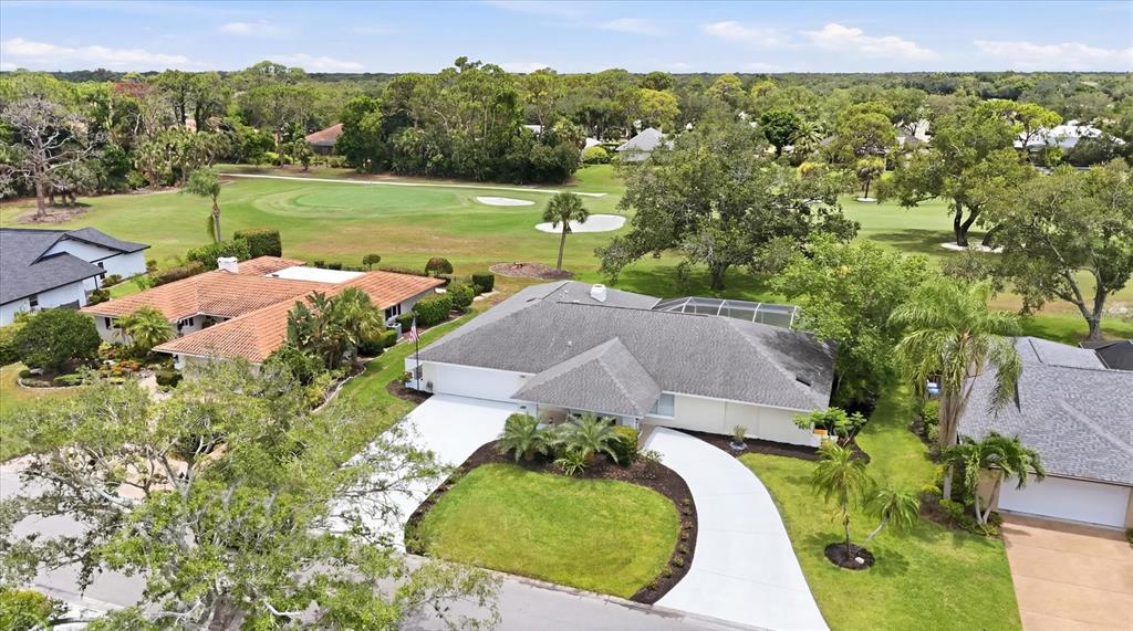 An aerial view shows a residential house with a gray roof next to a golf course — 3900 TORREY PINES BOULEVARD, SARASOTA, FL