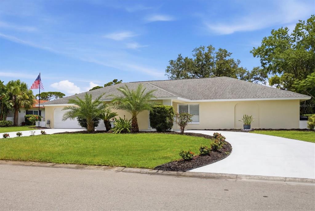 A single-story house with a light-colored exterior, a curved driveway, and palm trees — 3900 TORREY PINES BOULEVARD, SARASOTA, FL