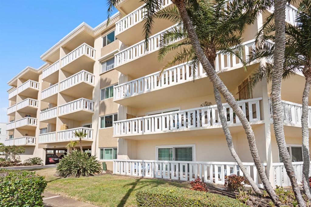 A multi-story apartment building features white balconies and palm trees in front — 1200 N SHORE DRIVE NE UNIT 316, ST PETERSBURG, FL
