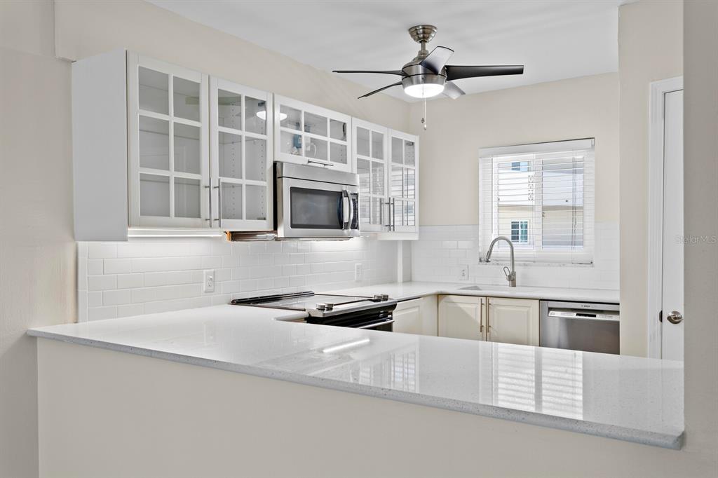 A kitchen with white cabinets, a stainless steel microwave, and white quartz countertops — 1200 N SHORE DRIVE NE UNIT 316, ST PETERSBURG, FL
