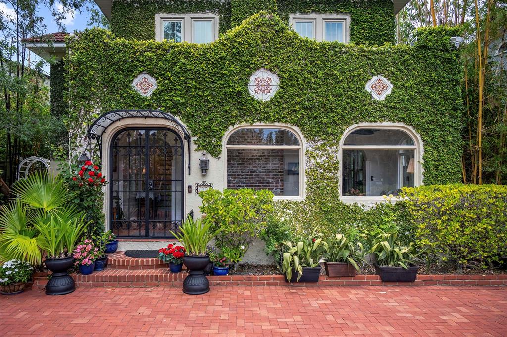 The exterior of a house features a brick driveway, ivy-covered walls, and arched windows — 710 SPRINGDALE ROAD, ORLANDO, FL