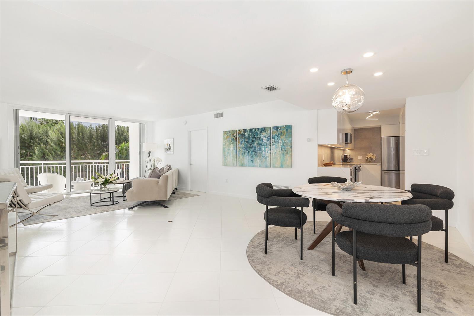A bright, open-concept living and dining area with white tile floors and a balcony view — 2780 S Ocean Boulevard # 311, Palm Beach FL 33480, PALM BEACH, FL