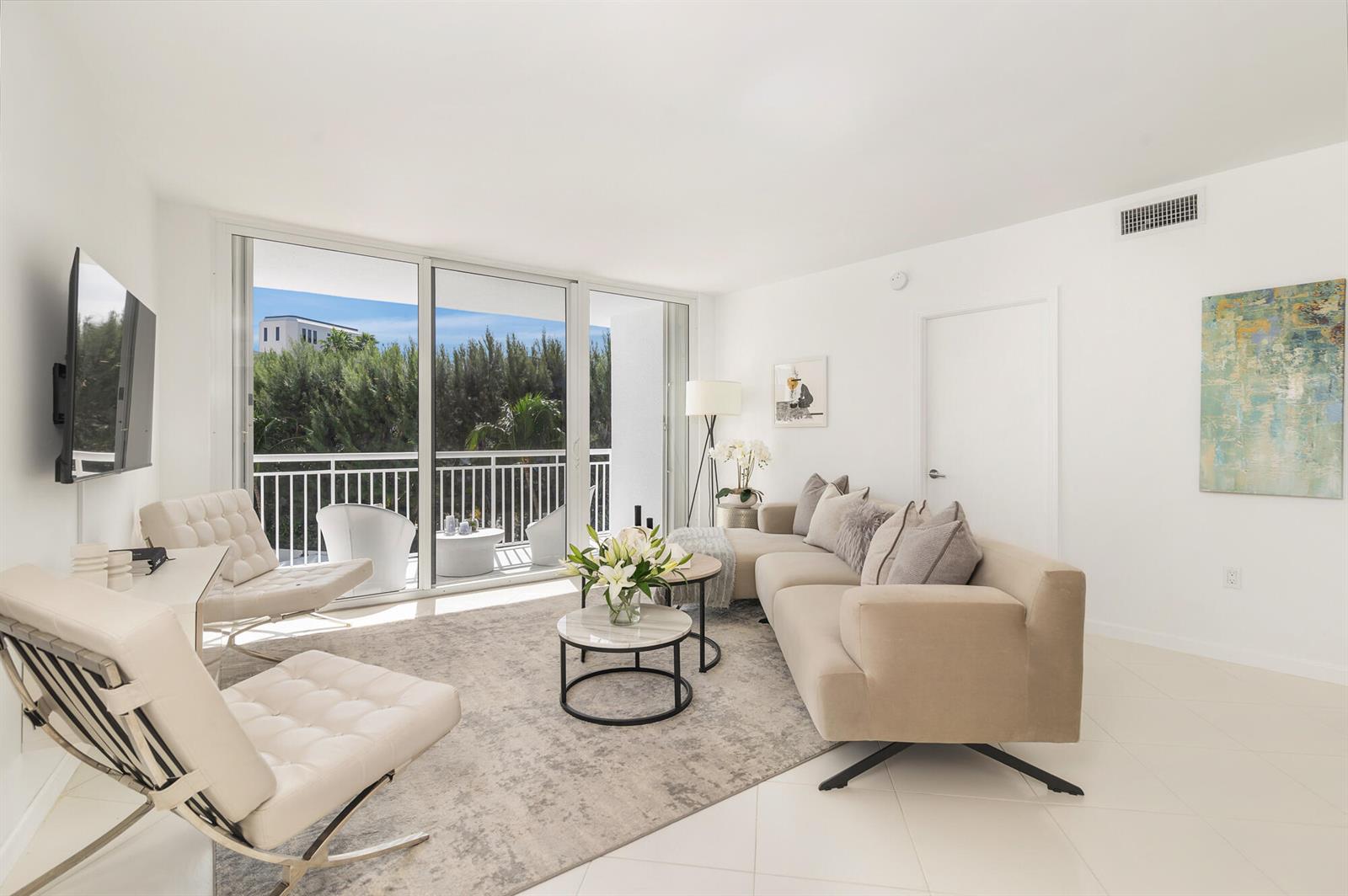 A bright living room features white tile floors, a beige sectional, and a balcony view — 2780 S Ocean Boulevard # 311, Palm Beach FL 33480, PALM BEACH, FL