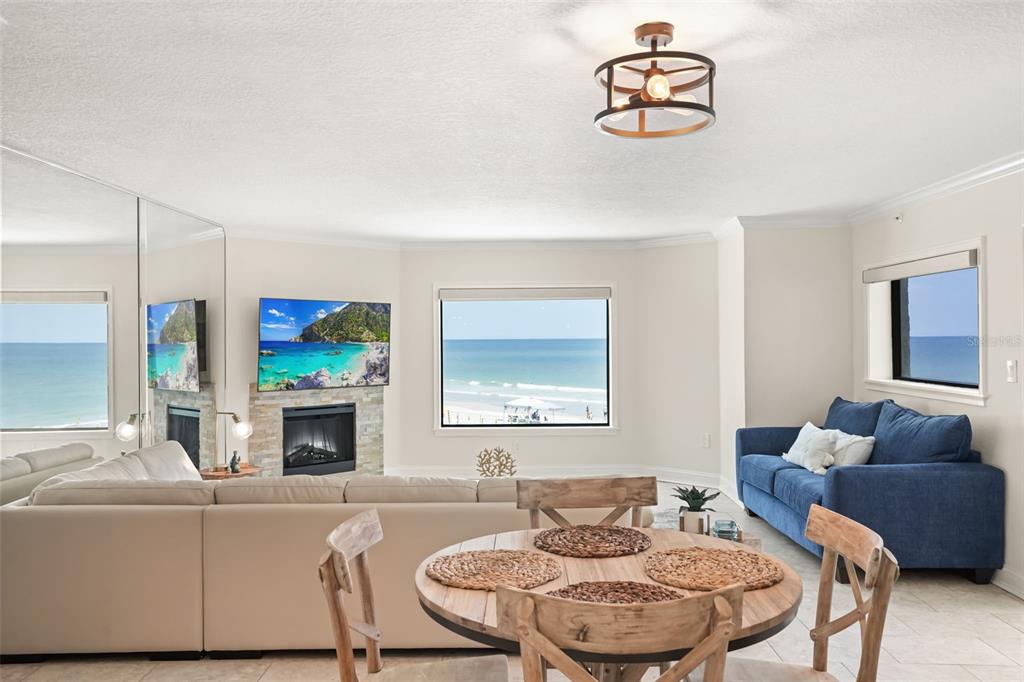 A living and dining area features a fireplace, ocean views, and a blue sofa — 5207 S ATLANTIC AVENUE UNIT 222, NEW SMYRNA BEACH, FL