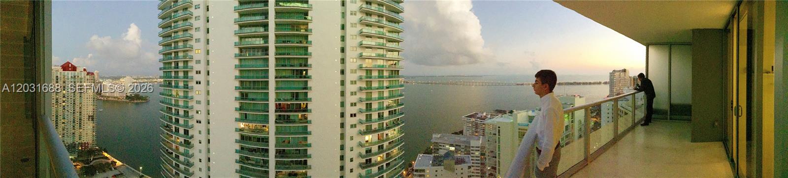 A panoramic view from a high-rise balcony overlooking a bay and city skyline — 1300 Brickell Bay Dr # 3506, Miami FL 33131, MIAMI, FL