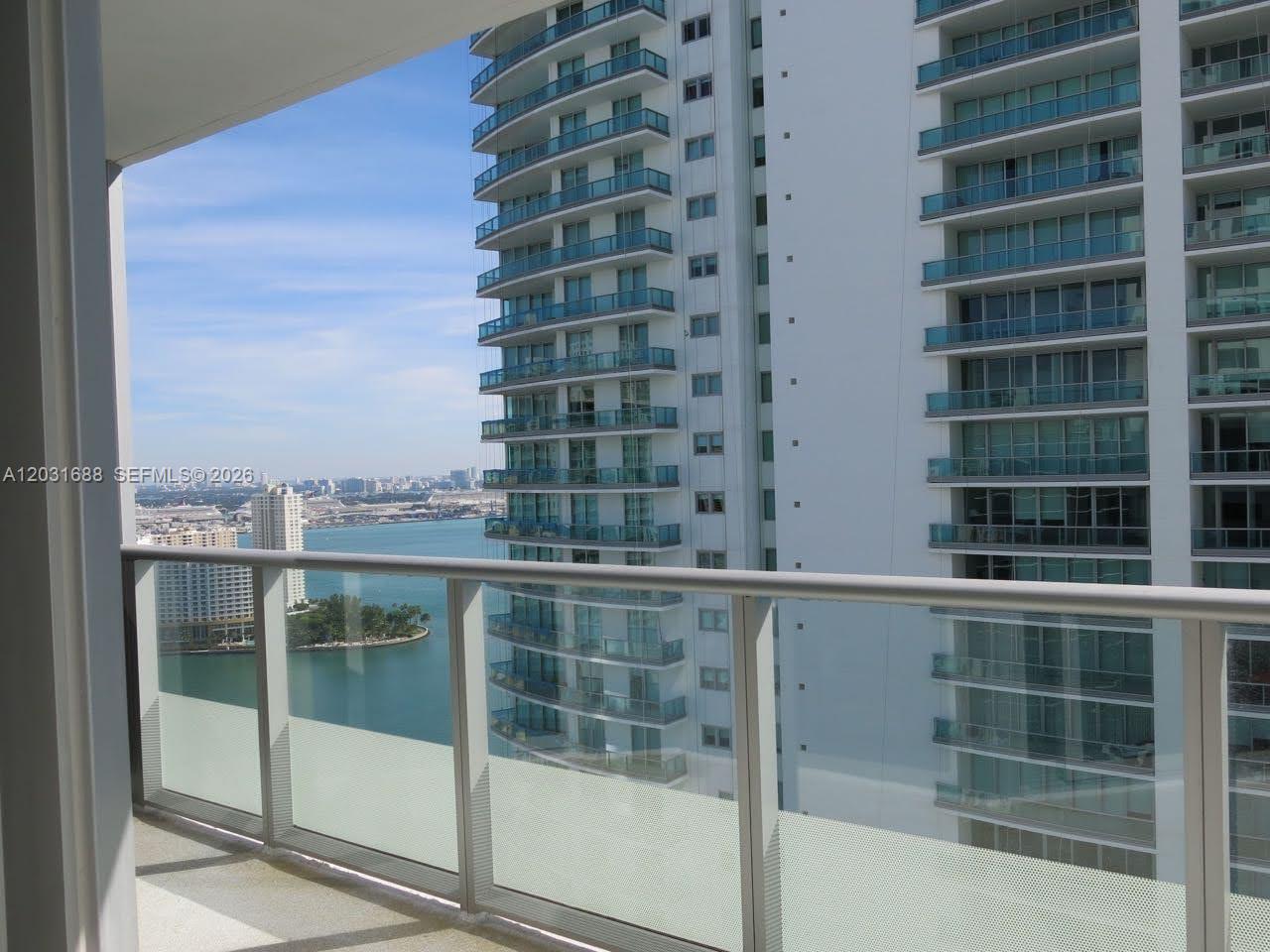 A balcony view overlooks a bay, a small island, and several high-rise apartment buildings — 1300 Brickell Bay Dr # 3506, Miami FL 33131, MIAMI, FL