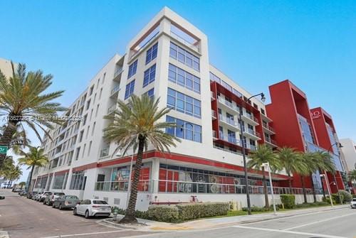 A modern multi-story apartment building with white and red exterior walls and palm trees — 777 N Ocean Dr # S216, Hollywood FL 33019, HOLLYWOOD, FL