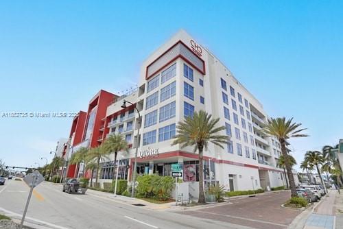 A multi-story commercial building with a red and white facade stands near a street — 777 N Ocean Dr # S216, Hollywood FL 33019, HOLLYWOOD, FL