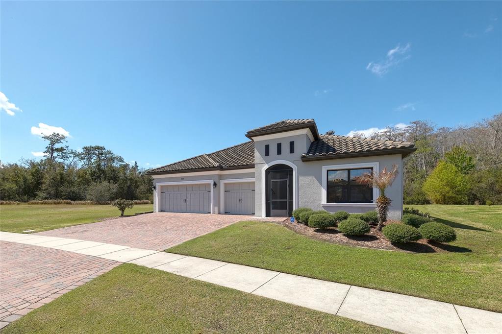 A single-story house with a tiled roof, two garage doors, and a paved driveway — 3081 AGOSTINO TERRACE, KISSIMMEE, FL