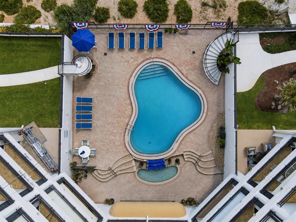 An aerial view shows a swimming pool and hot tub surrounded by a patio area — 395 S ATLANTIC AVENUE UNIT 402, ORMOND BEACH, FL