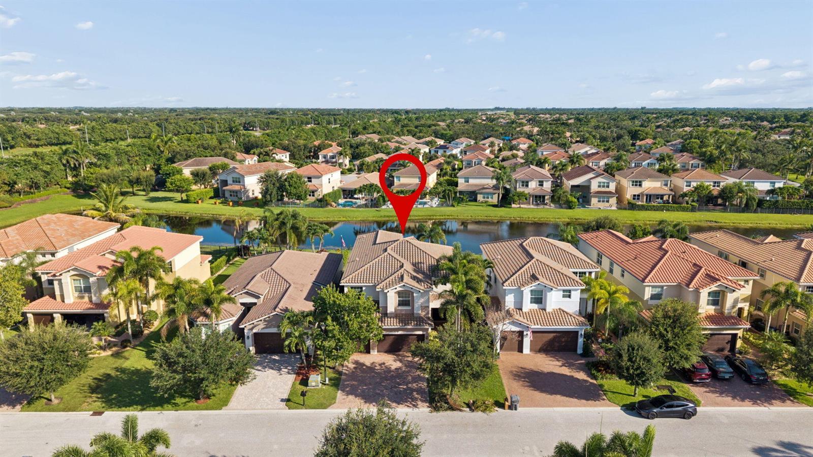 An aerial view shows a row of suburban houses with tile roofs facing a lake — 8256 Savara Streams Lane, Boynton Beach FL 33473, BOYNTON BEACH, FL