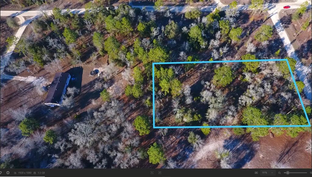 An aerial view shows a rectangular plot of land outlined in blue near a house — SE 137TH COURT, MORRISTON, FL