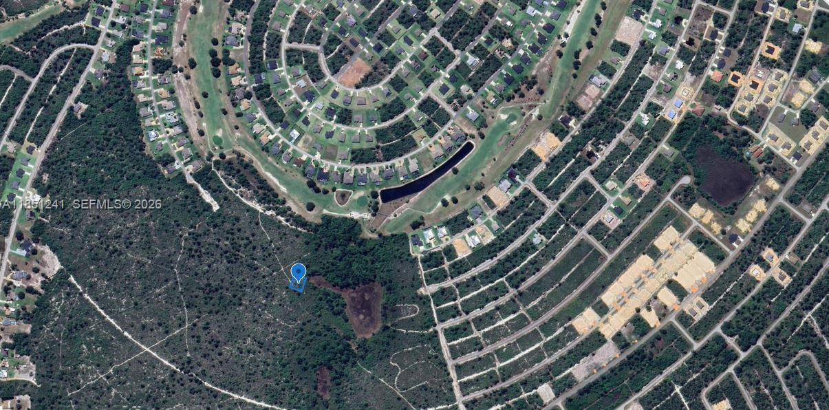 A golf course clubhouse with a blue metal roof sits beside a pond and bunker — 6579 San Bruno Dr, Sebring FL 33872, SEBRING, FL
