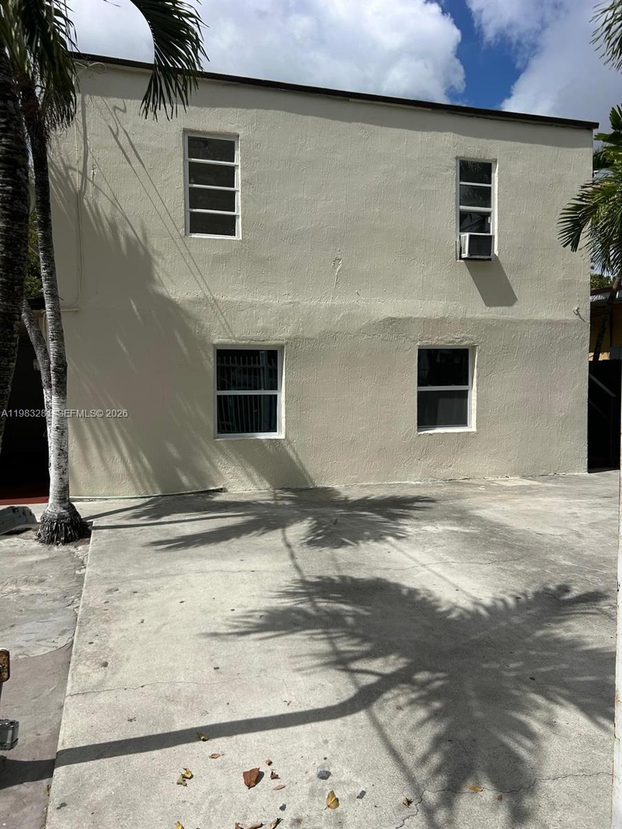 The exterior of a two-story beige building features four windows and a concrete driveway — 2908 NW 14 ct # 1, Miami FL 33142, MIAMI, FL