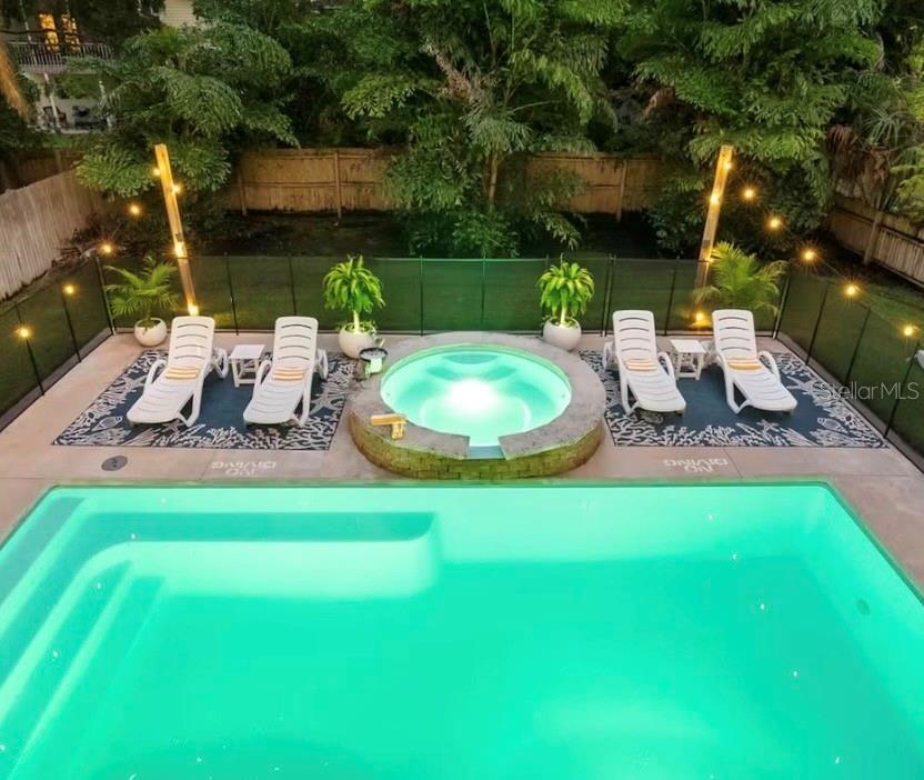 An elevated view of a backyard swimming pool and a circular hot tub with lounge chairs — 313 CRYSTAL BEACH AVENUE, CRYSTAL BEACH, FL