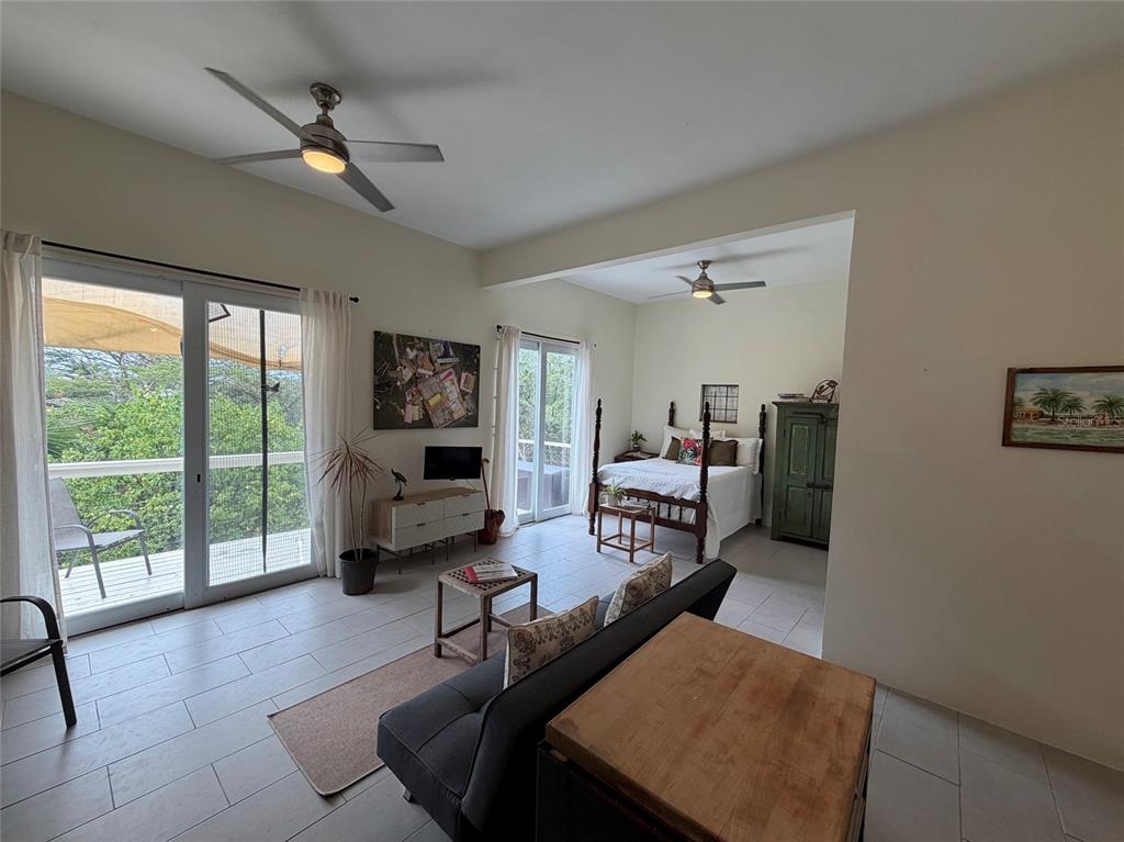 An open-concept bedroom and living area features tile floors, two ceiling fans, and balcony access — 311 VILLA BORINQUEN, VIEQUES, PR