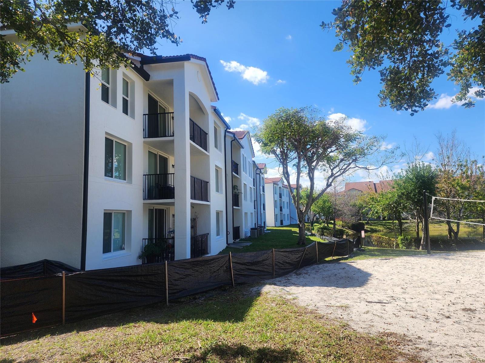An exterior view of a multi-story apartment building with an open-air staircase and balconies — 317 Villa Circle # 317, Boynton Beach FL 33435, BOYNTON BEACH, FL