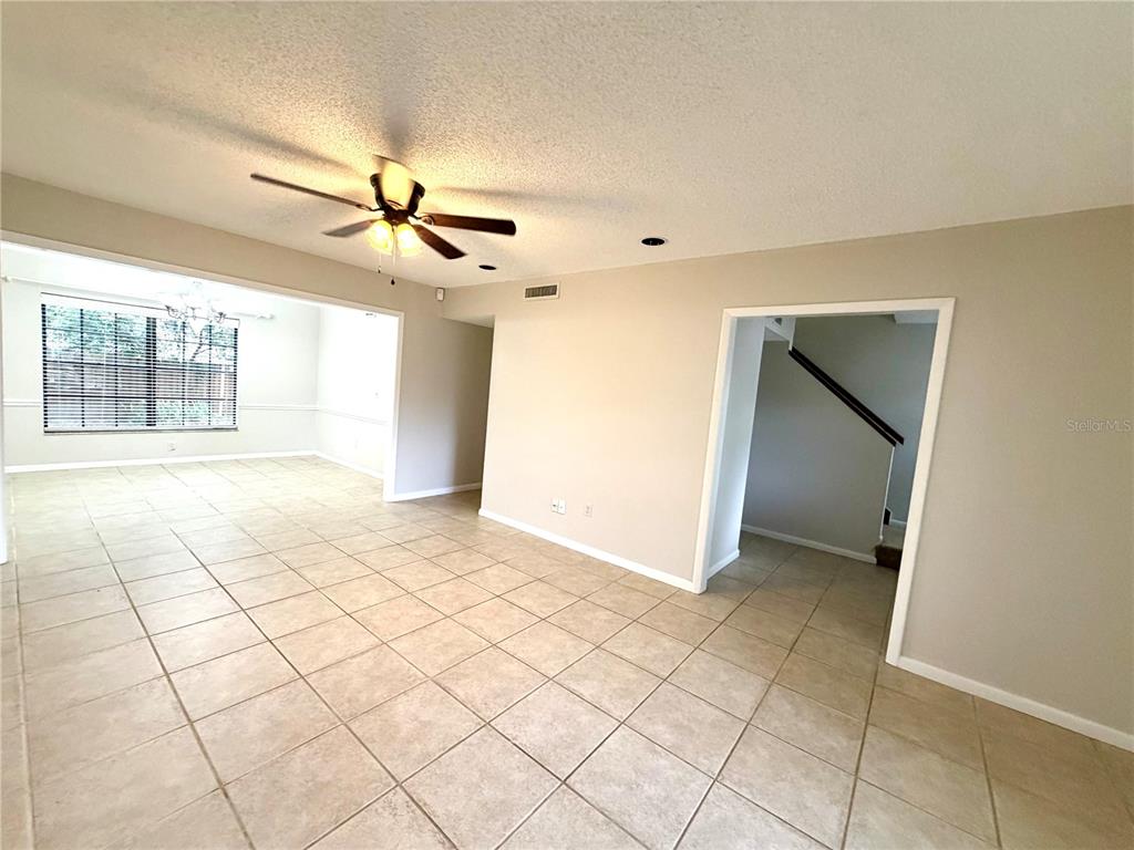 A room with light-colored tile flooring, beige walls, and a ceiling fan — 14904 LAKE FOREST DRIVE, LUTZ, FL