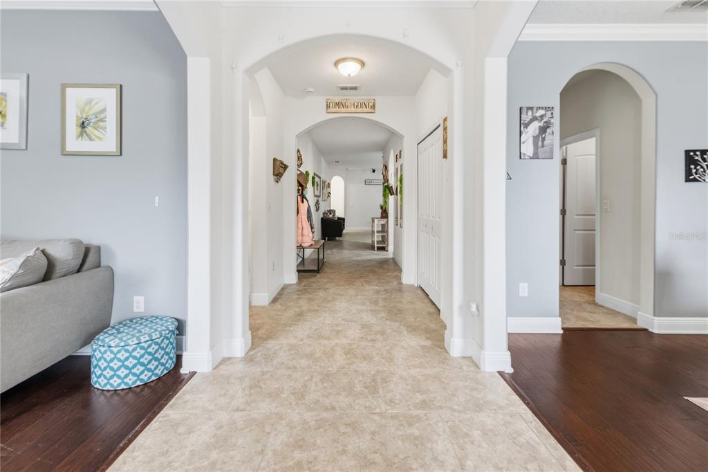A tiled hallway with arched entryways leads from a living area toward a back room — 433 AMETHYST AVENUE, AUBURNDALE, FL