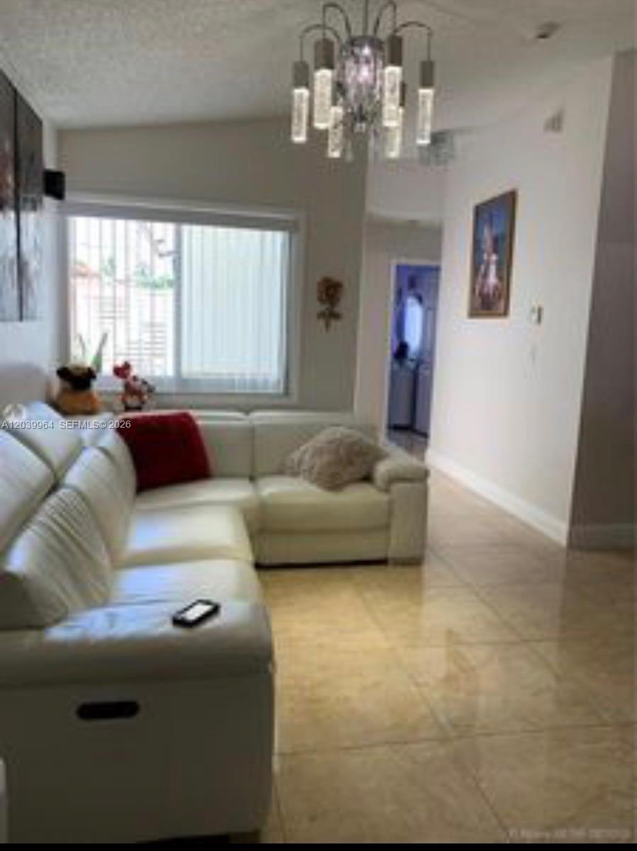 An empty room features beige tile flooring, white walls, and a large mirrored wall — 2854 W 75th Ter, Hialeah FL 33018, HIALEAH, FL