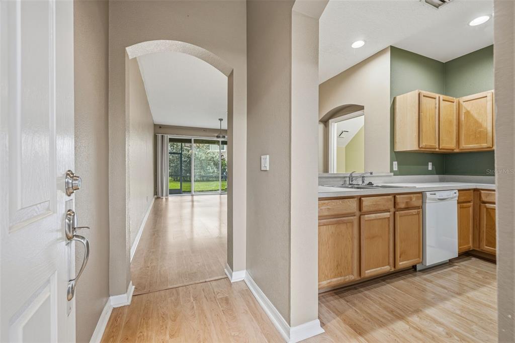 An entryway leads into a kitchen with wood cabinets and a view of a living area — 11221 WINDSOR PLACE CIRCLE, TAMPA, FL
