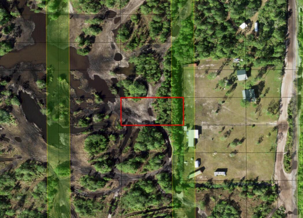 An aerial map view showing a red-outlined rectangular plot of land near wooded, marshy areas — 0 Holopaw Groves Road, FL 34772, FL