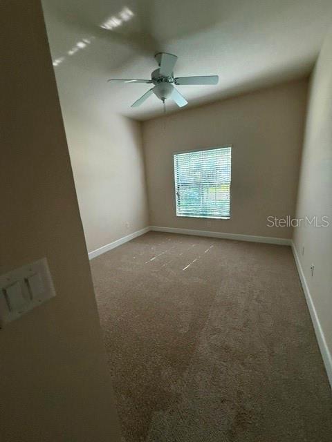 A bedroom features beige walls, tan carpeting, a ceiling fan, and a window with blinds — 2834 SHETLAND RIDGE DRIVE, VALRICO, FL