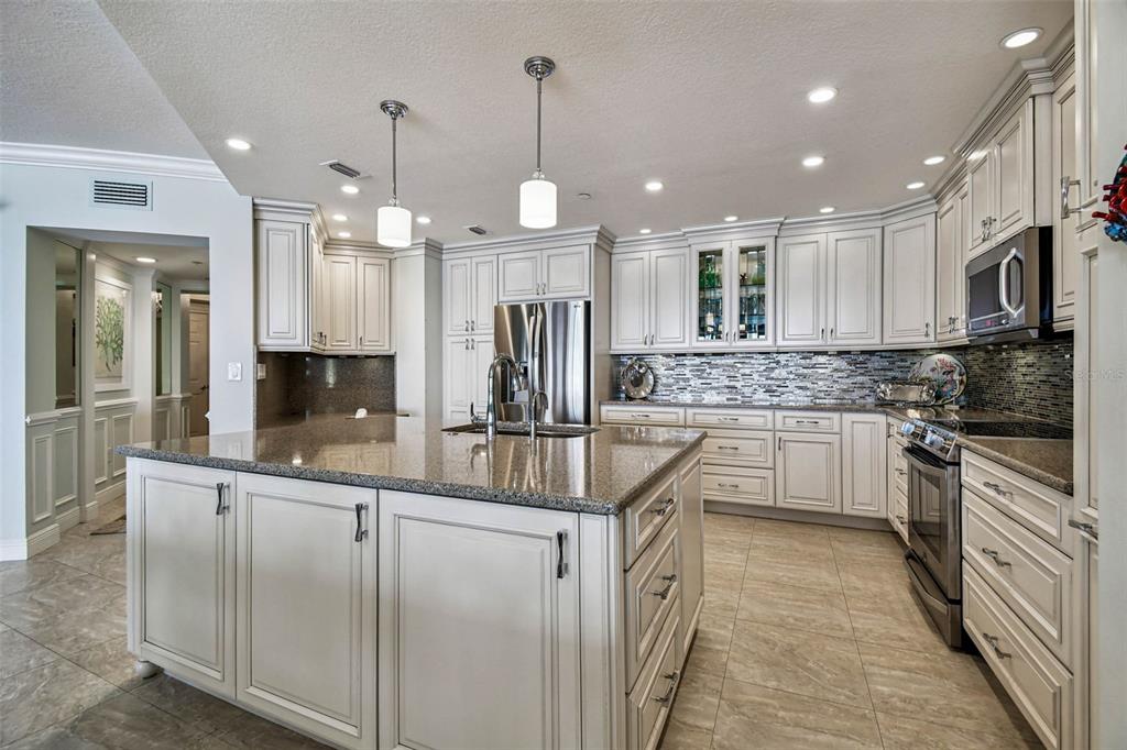 A kitchen with white cabinetry, granite countertops, stainless steel appliances, and a large center island — 16750 GULF BOULEVARD UNIT 315-A, NORTH REDINGTON BEACH, FL
