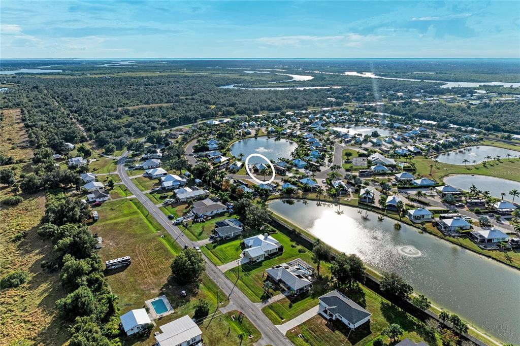 An aerial view shows a residential neighborhood with houses surrounding several small lakes — 8867 SW SAND CRANE CIRCLE LOT 21, ARCADIA, FL
