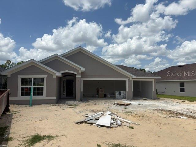 A newly constructed single-story house with a beige exterior, a garage, and an unfinished yard — 7184 SW 179TH COURT ROAD, DUNNELLON, FL