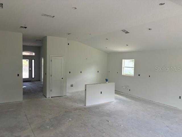 An unfinished room with white walls, recessed lighting, and a central half-wall partition — 7184 SW 179TH COURT ROAD, DUNNELLON, FL