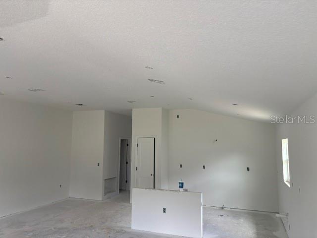 An unfinished room with white walls, a vaulted ceiling, and a central half wall — 7184 SW 179TH COURT ROAD, DUNNELLON, FL