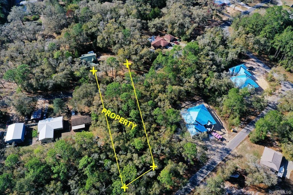 An aerial view shows a wooded lot marked with yellow lines indicating property boundaries — 2663 W CYPRESS DRIVE, DUNNELLON, FL