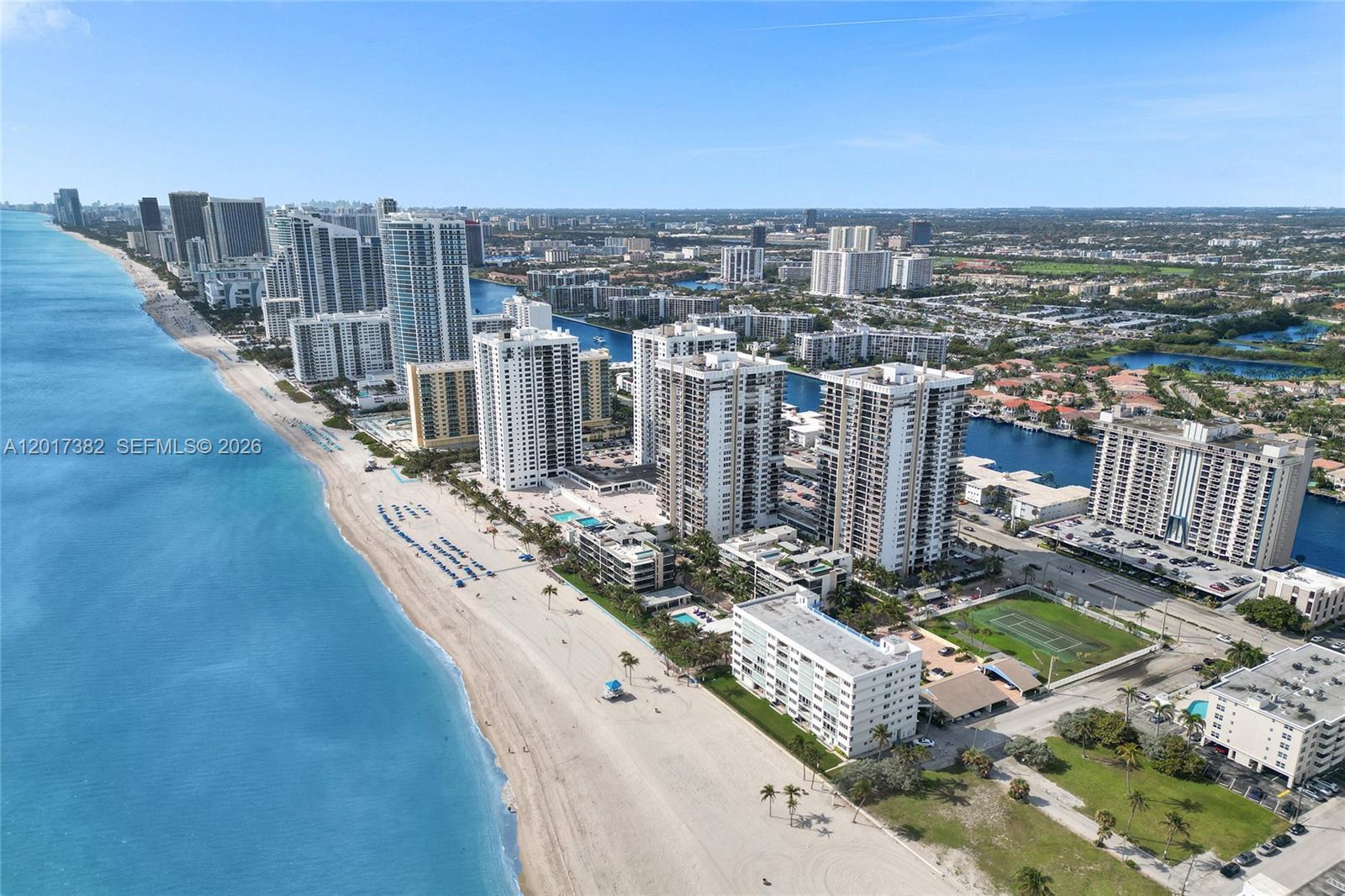 An aerial view shows high-rise residential buildings along a sandy beach and oceanfront — 1600 S Ocean Dr # 16B, Hollywood FL 33019, HOLLYWOOD, FL
