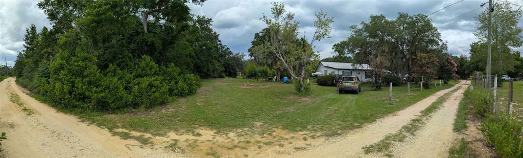 A panoramic view of a rural property featuring a house, a car, and dirt roads — 20877 SE 143RD PLACE, UMATILLA, FL