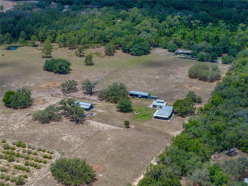An aerial view shows a rural property with a house, outbuildings, and fenced pasture land — 10790 JIM EDWARDS ROAD, HAINES CITY, FL