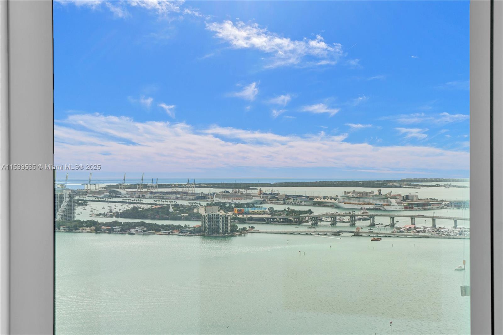 A high-angle view through a window shows a bay, cruise ships, and a bridge — 700 NE 26th Ter # 3505, Miami FL 33137, MIAMI, FL