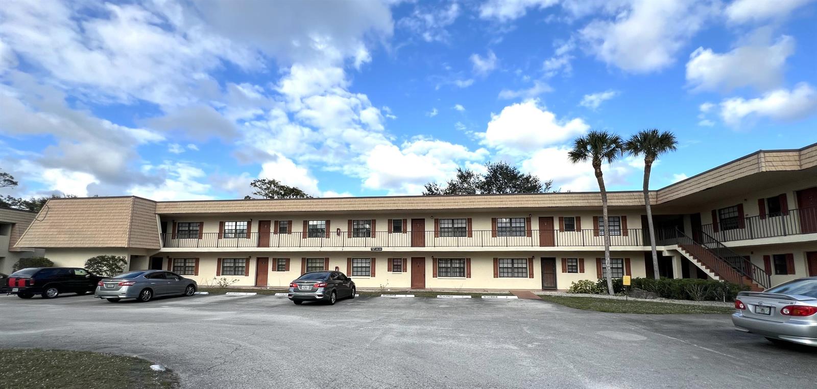 A two-story apartment building with a parking lot in front and two palm trees — 4205 Oak Terrace Drive # 4205, FL 33463, FL