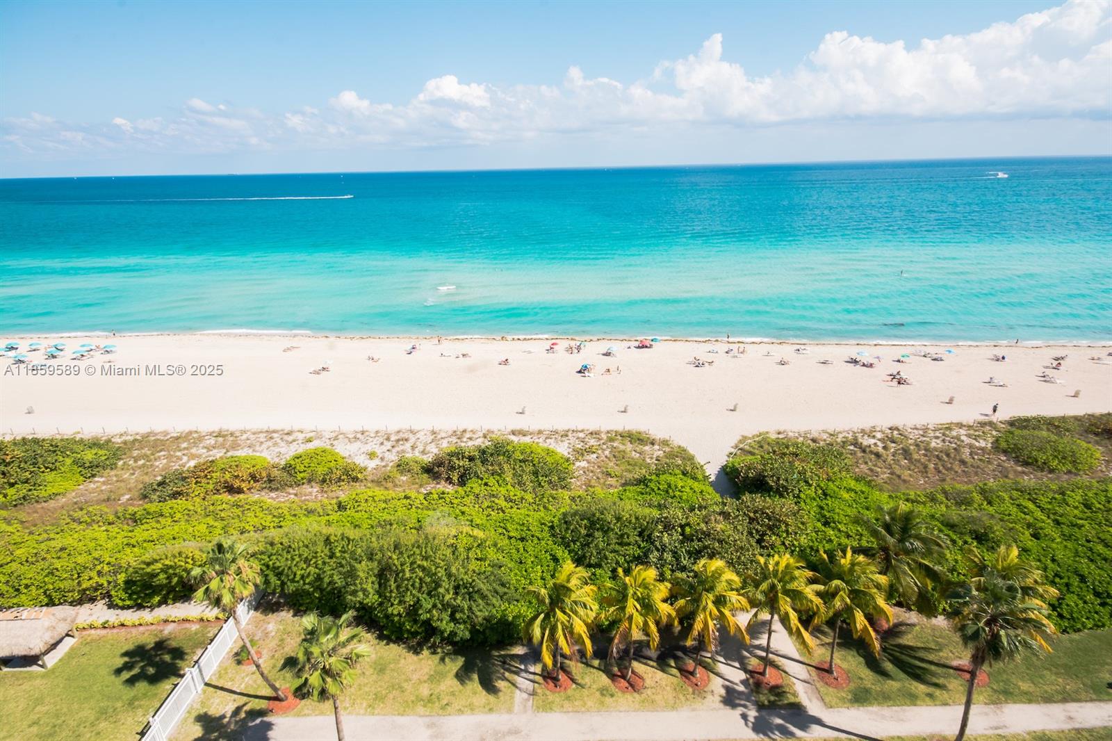 An aerial view shows a sandy beach with turquoise water, dunes, and palm trees — 5601 Collins Ave # 1204, Miami Beach FL 33140, MIAMI BEACH, FL