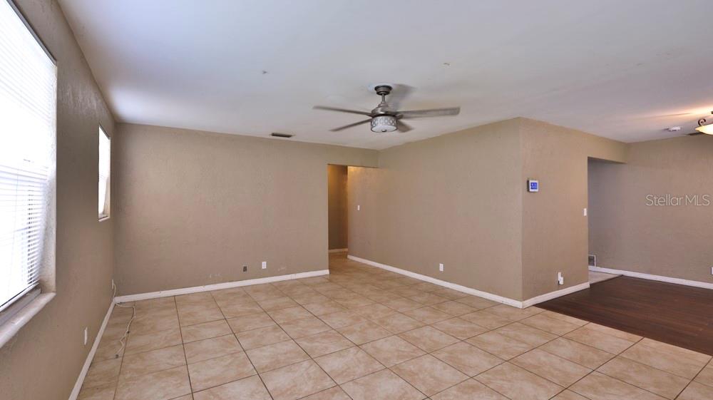 An empty room with tan walls, beige tile flooring, and a ceiling fan — 347 PLEASANT STREET, DAYTONA BEACH, FL