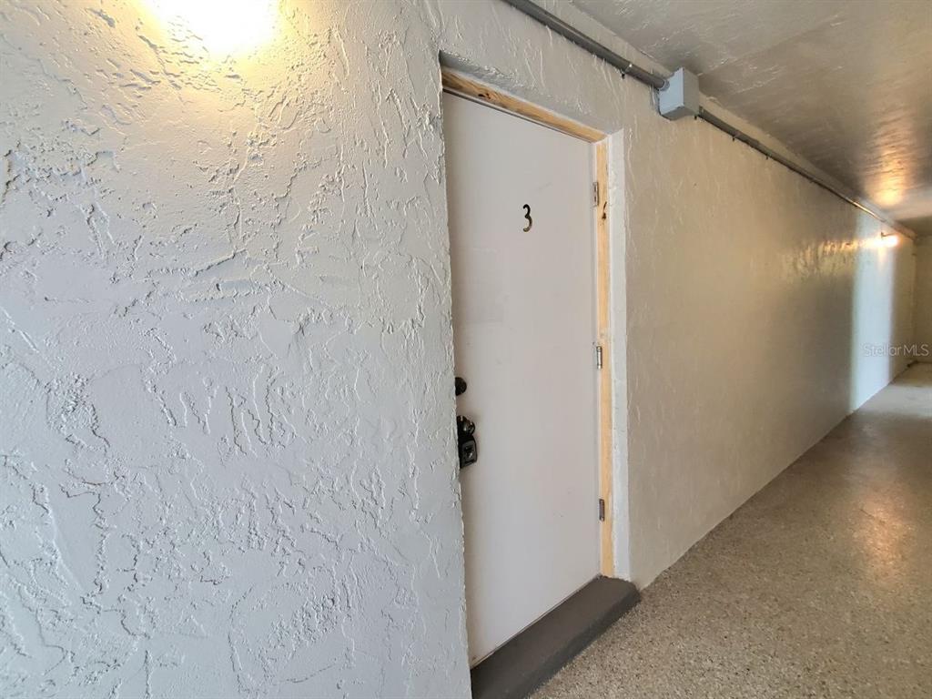 A white door labeled with the number three is set in a textured wall — 8151 BLIND PASS ROAD UNIT 3, ST PETE BEACH, FL