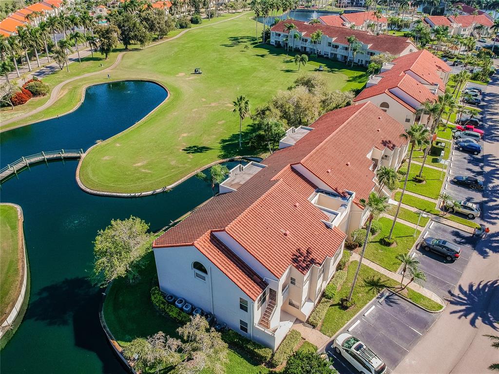 An aerial view of a multi-story residential building with a red tile roof near water — 6000 BAHIA DEL MAR CIRCLE UNIT 130, ST PETERSBURG, FL