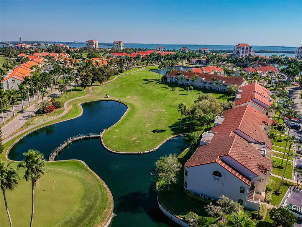 An aerial view shows a multi-story residential complex overlooking a golf course and a pond — 6000 BAHIA DEL MAR CIRCLE UNIT 130, ST PETERSBURG, FL